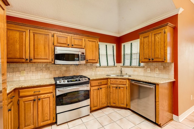 kitchen with tasteful backsplash, appliances with stainless steel finishes, sink, and light tile patterned floors