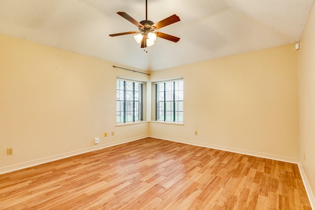 empty room with ceiling fan, lofted ceiling, and light hardwood / wood-style floors