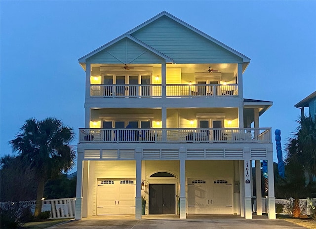 view of front of property with ceiling fan, a balcony, and a garage