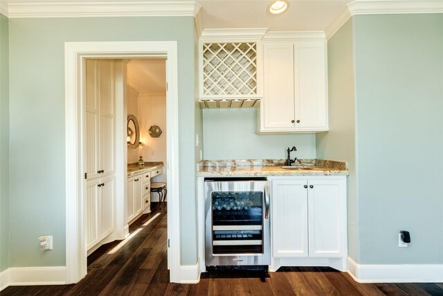 bar with sink, crown molding, beverage cooler, and white cabinets