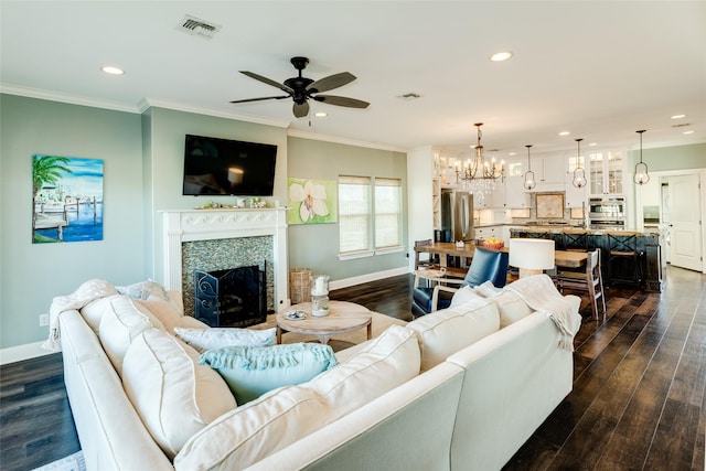 living room featuring ornamental molding, dark hardwood / wood-style floors, and ceiling fan with notable chandelier