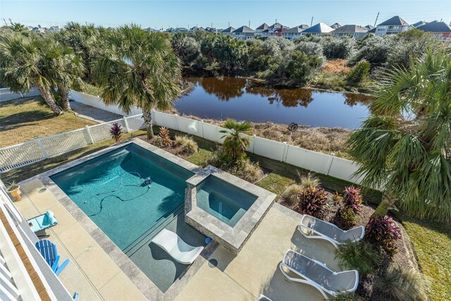 view of swimming pool with a water view and an in ground hot tub