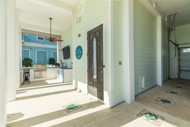 view of exterior entry featuring an outdoor kitchen and sink