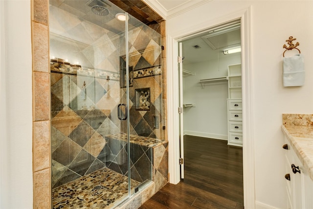 bathroom with vanity, crown molding, wood-type flooring, and a shower with door