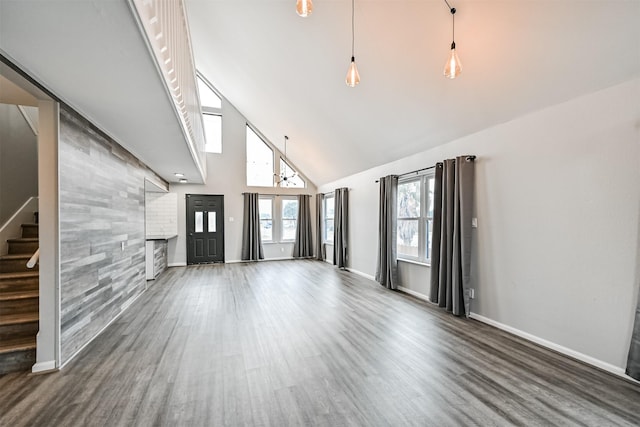 unfurnished living room with dark wood-type flooring and high vaulted ceiling