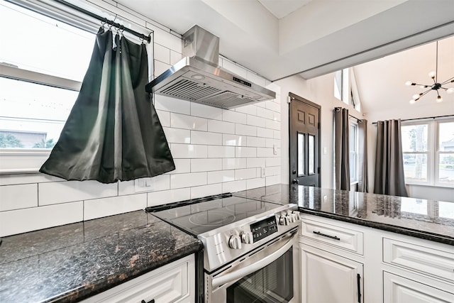 kitchen featuring tasteful backsplash, ventilation hood, stainless steel electric range, and white cabinets