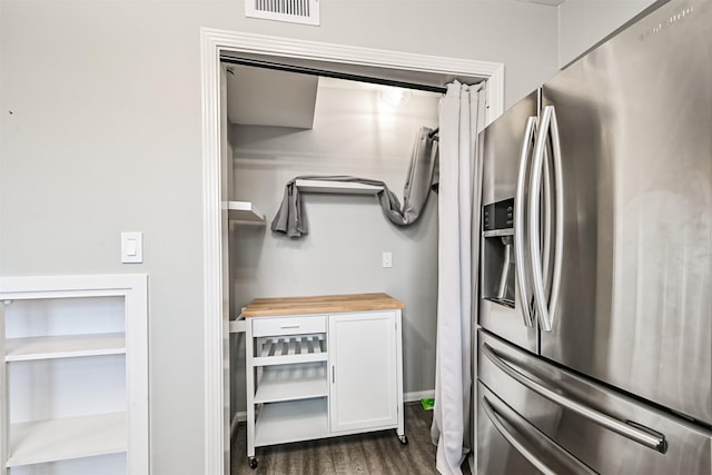 kitchen featuring white cabinetry, butcher block counters, dark hardwood / wood-style floors, and stainless steel fridge with ice dispenser