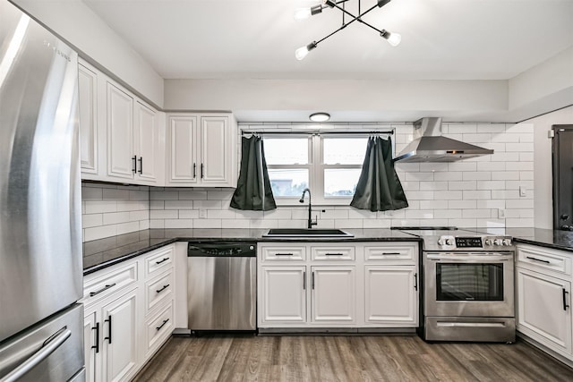 kitchen featuring sink, appliances with stainless steel finishes, white cabinetry, backsplash, and wall chimney exhaust hood