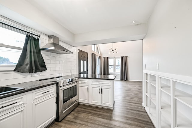 kitchen with electric range, kitchen peninsula, wall chimney range hood, decorative backsplash, and white cabinets