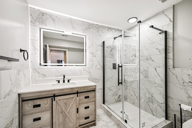 bathroom with a shower with door, vanity, and tile walls