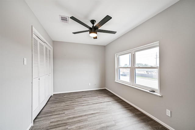 unfurnished bedroom featuring hardwood / wood-style floors, a closet, and ceiling fan