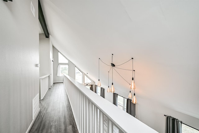 corridor featuring dark wood-type flooring and vaulted ceiling with beams