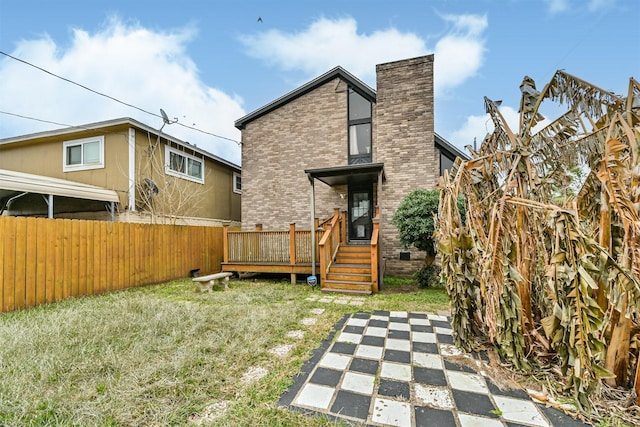 rear view of house with a yard and a deck