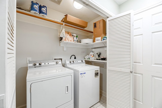 laundry room with light tile patterned floors and washer and clothes dryer