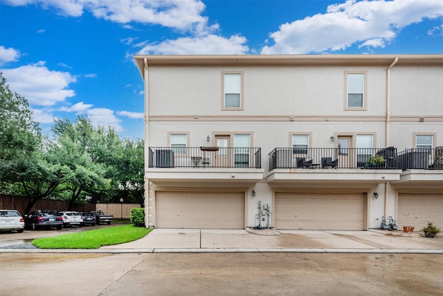 view of property with a balcony and a garage