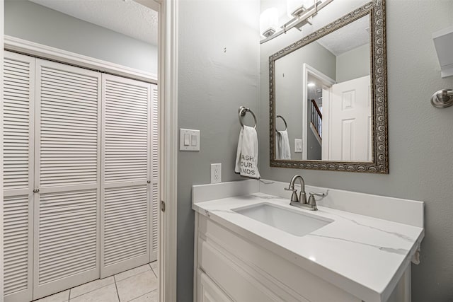 bathroom with vanity, tile patterned flooring, and a textured ceiling