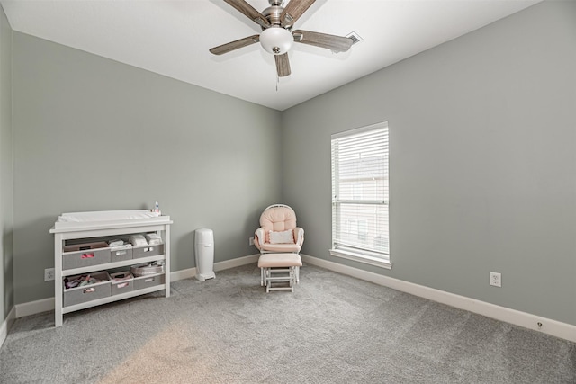 living area featuring carpet floors and ceiling fan