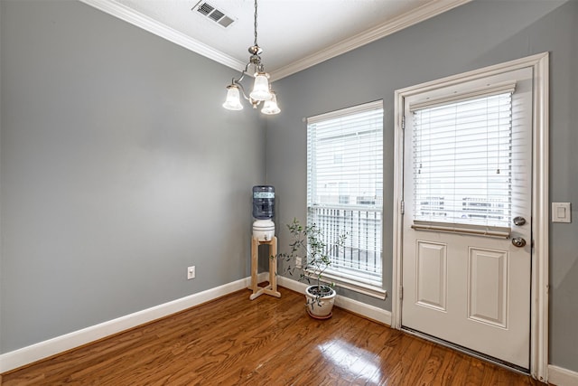 entryway featuring a notable chandelier, crown molding, and wood-type flooring