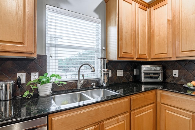 kitchen featuring dark stone countertops, sink, decorative backsplash, and dishwasher