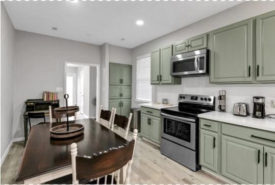 kitchen featuring stainless steel appliances, green cabinets, and light hardwood / wood-style floors