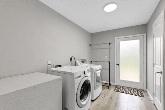 washroom featuring washer and clothes dryer and light hardwood / wood-style floors