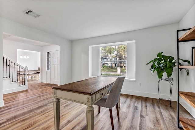 office space featuring a notable chandelier and light wood-type flooring