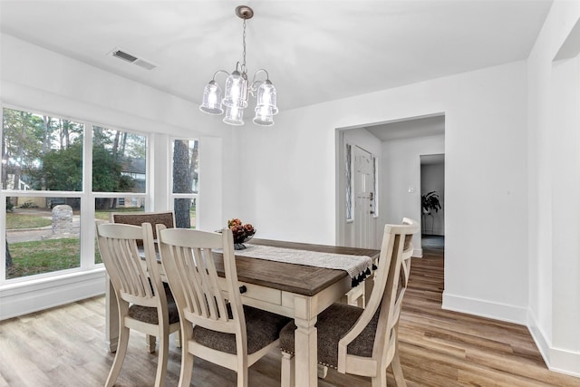 dining space featuring a chandelier and light wood-type flooring