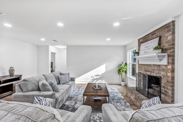 living room featuring a brick fireplace and hardwood / wood-style flooring