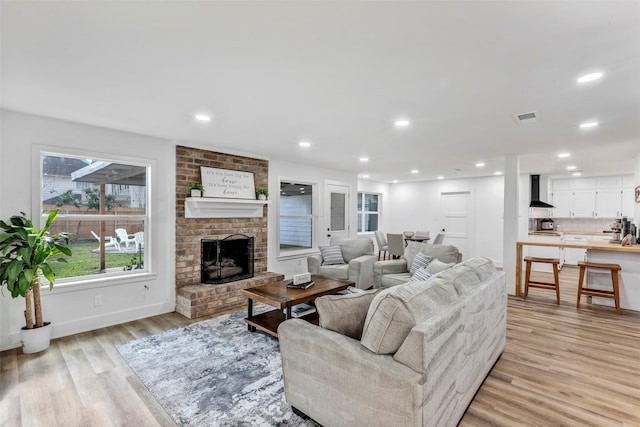 living room with a fireplace and light hardwood / wood-style flooring