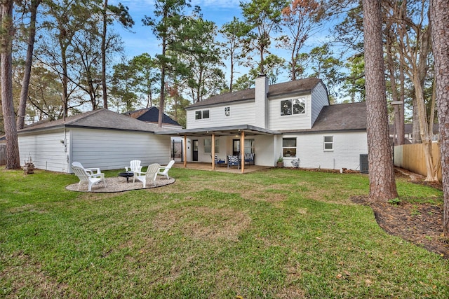 back of property featuring central AC, an outdoor fire pit, a yard, and a patio area