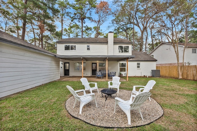 rear view of property with cooling unit, an outdoor fire pit, a yard, and a patio area