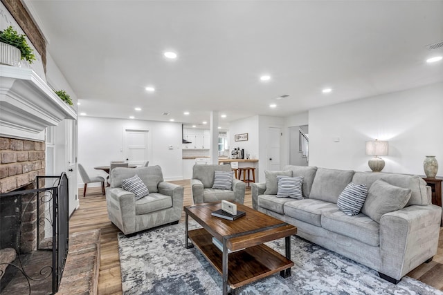 living room featuring hardwood / wood-style floors and a brick fireplace