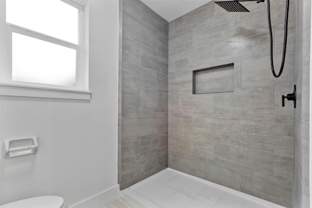 bathroom featuring toilet and tiled shower