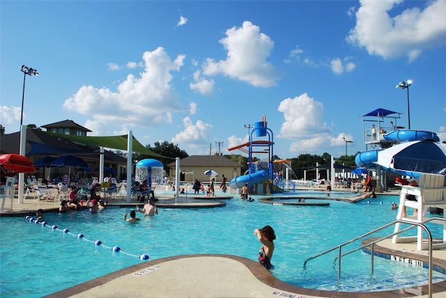 view of swimming pool featuring a hot tub and a water slide