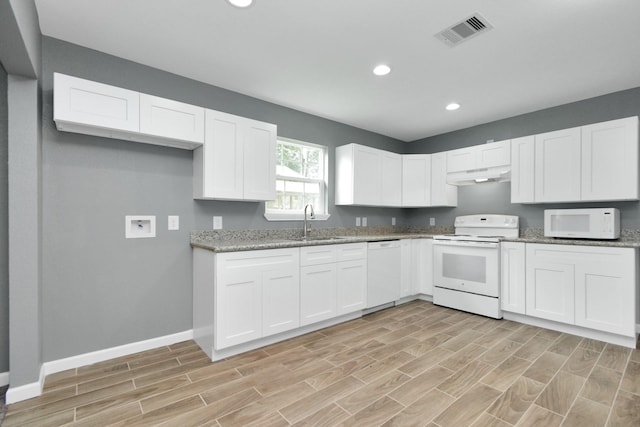 kitchen featuring white cabinetry, sink, white appliances, and stone countertops