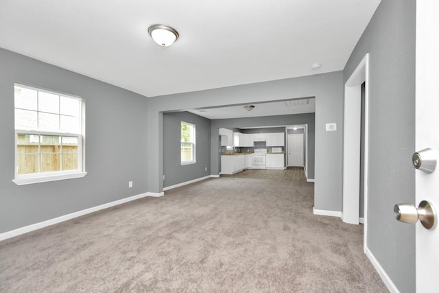 unfurnished living room featuring light colored carpet