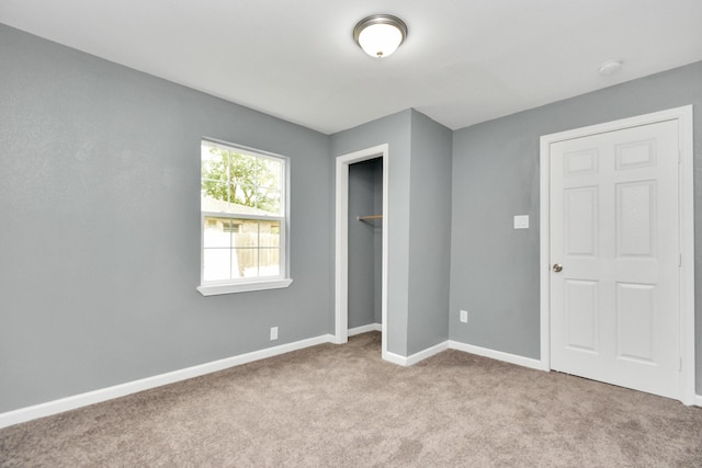 unfurnished bedroom with light carpet and a closet