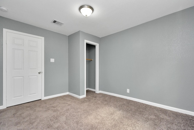 unfurnished bedroom featuring a closet and light carpet