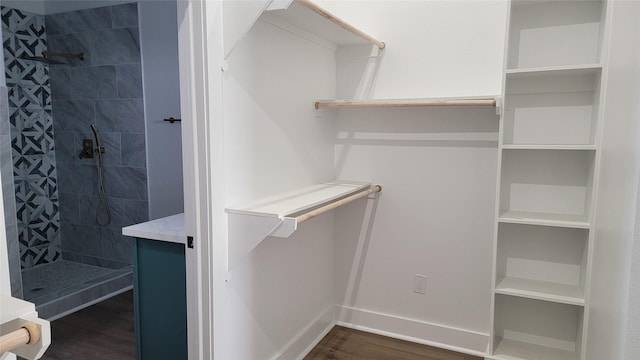 spacious closet with dark hardwood / wood-style flooring