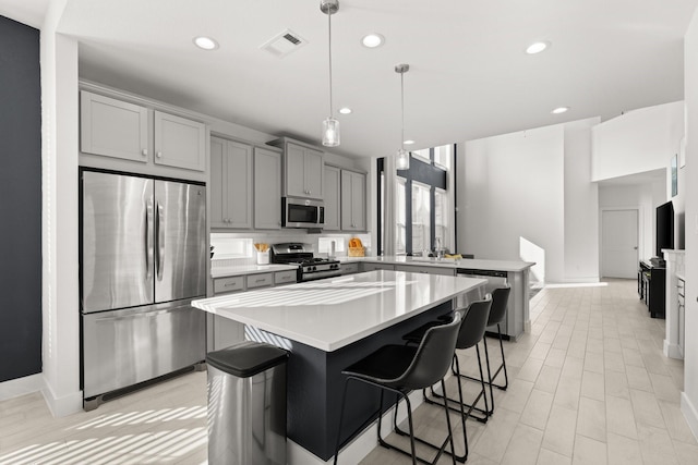 kitchen featuring stainless steel appliances, a kitchen island, and a kitchen breakfast bar