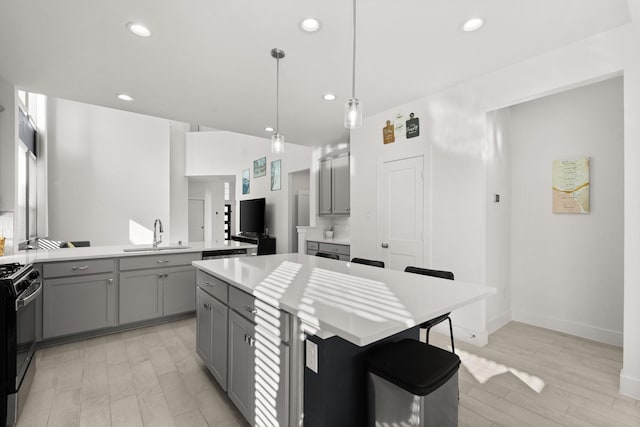 kitchen featuring sink, decorative light fixtures, a center island, black range with gas stovetop, and backsplash