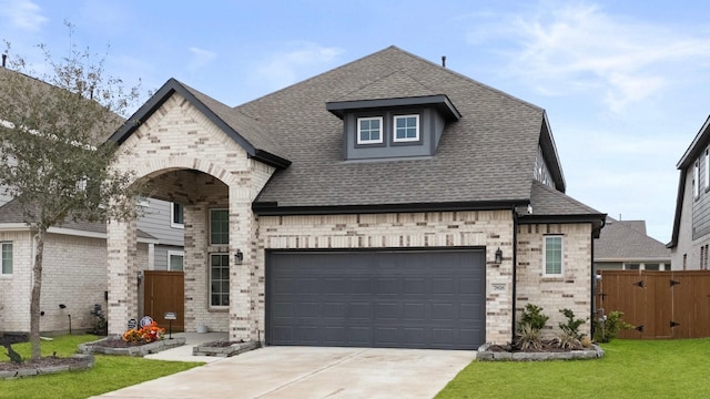 french country inspired facade featuring a garage and a front lawn