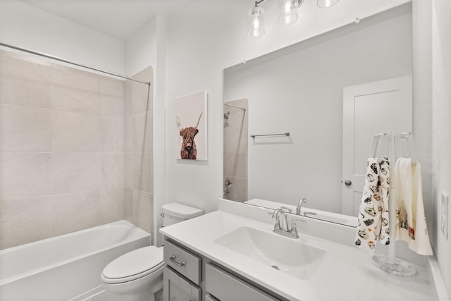 full bathroom featuring tiled shower / bath combo, vanity, and toilet