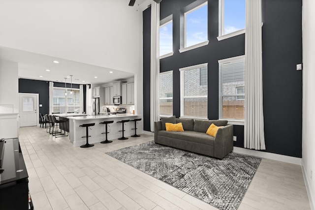 living room with a high ceiling and ceiling fan