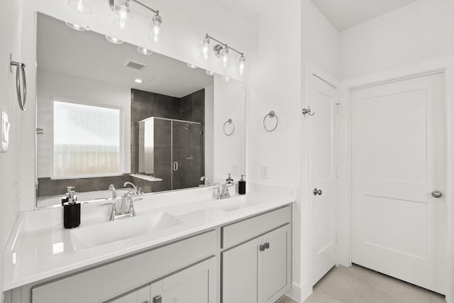 bathroom featuring tile patterned flooring, vanity, and a shower with door