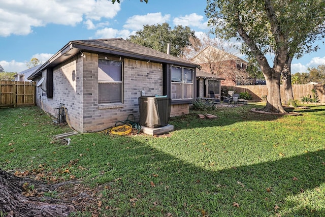 back of property featuring a lawn and a sunroom