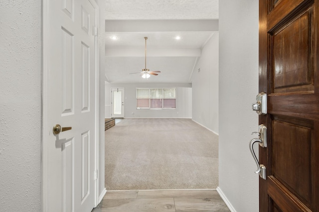 carpeted foyer entrance featuring vaulted ceiling and ceiling fan