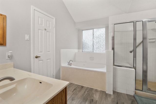 bathroom featuring lofted ceiling, vanity, wood-type flooring, and separate shower and tub