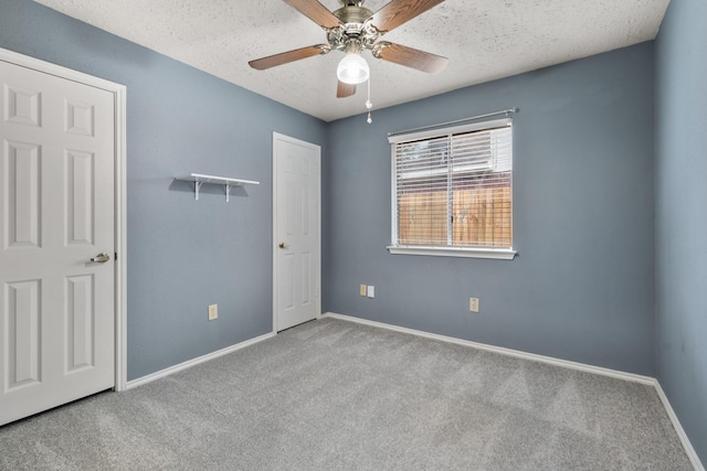 carpeted empty room with ceiling fan and a textured ceiling