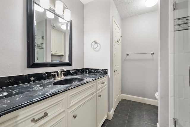 bathroom featuring tile patterned flooring, vanity, a textured ceiling, and toilet